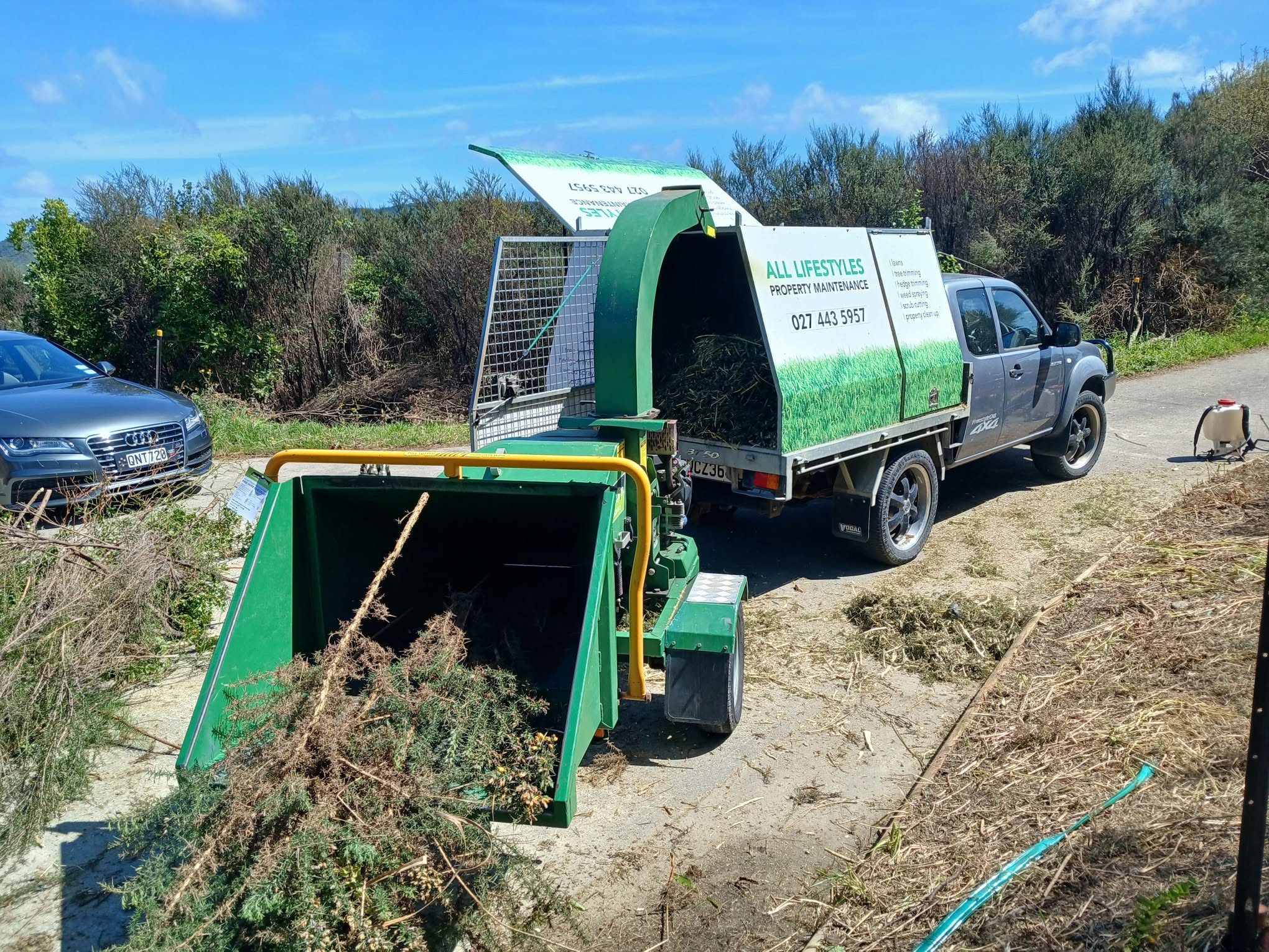 All Lifestyles Property Maintenance truck and wood chipper on a scrub cutting job